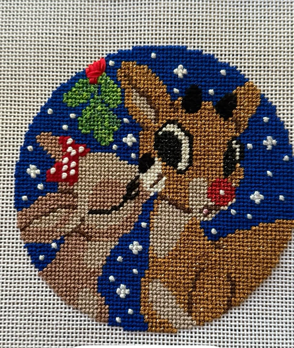 Needlepoint iconic reindeer design on a white fabric background
