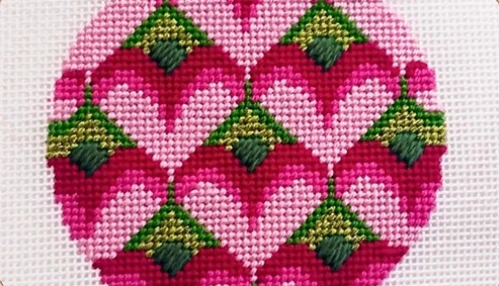 Needlepoint project with hearts on a white canvas